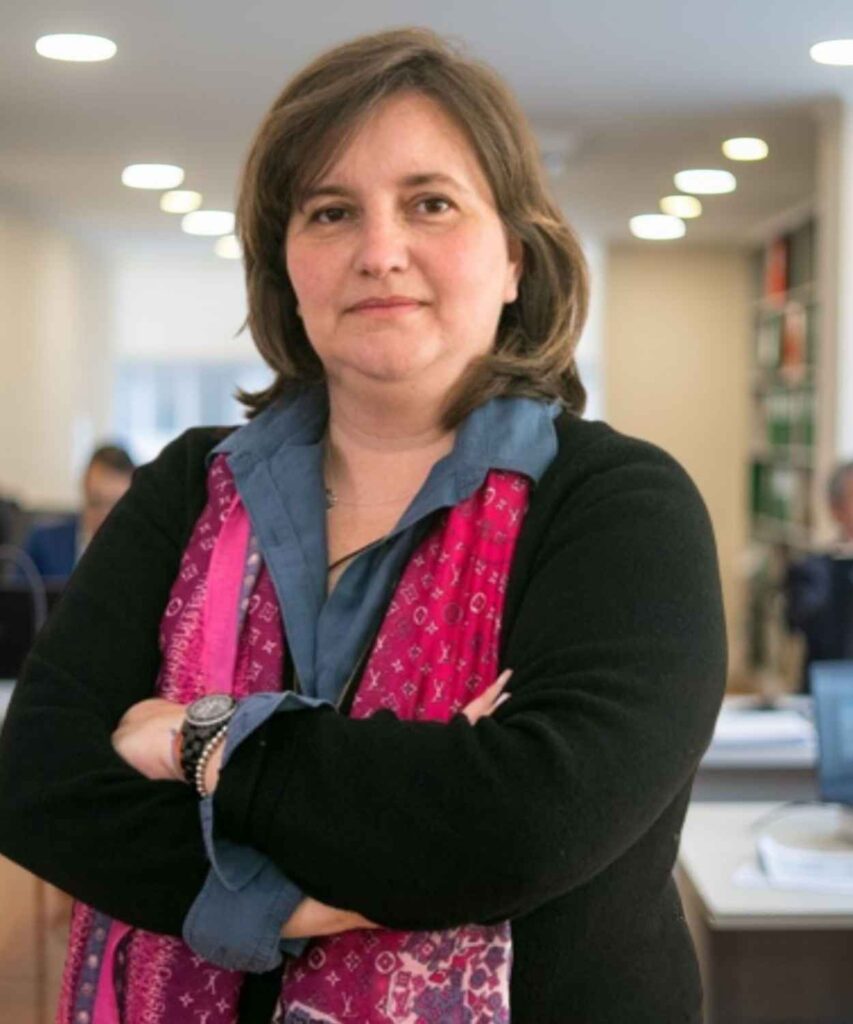 Coach Dora Sousa em postura confiante no escritório da Estrategor.