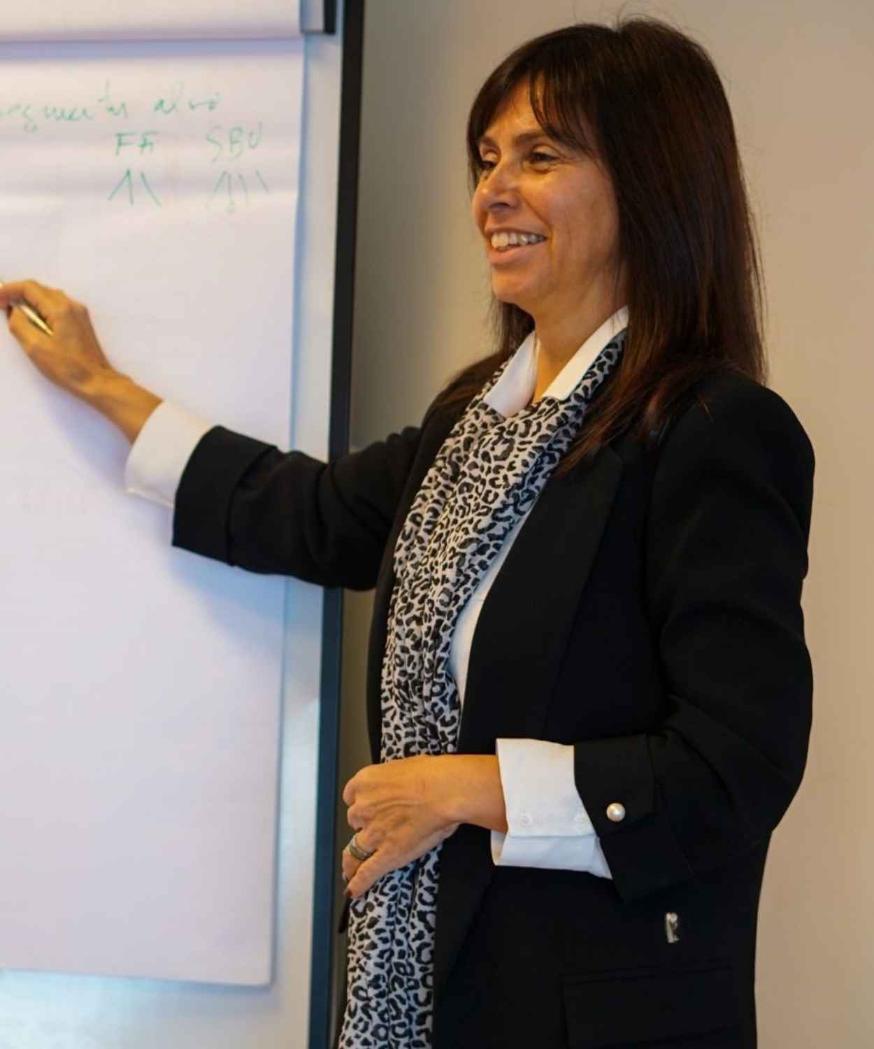 Maria Pinto, gestora de formação, a apresentar conceitos num flipchart durante uma sessão de formação.